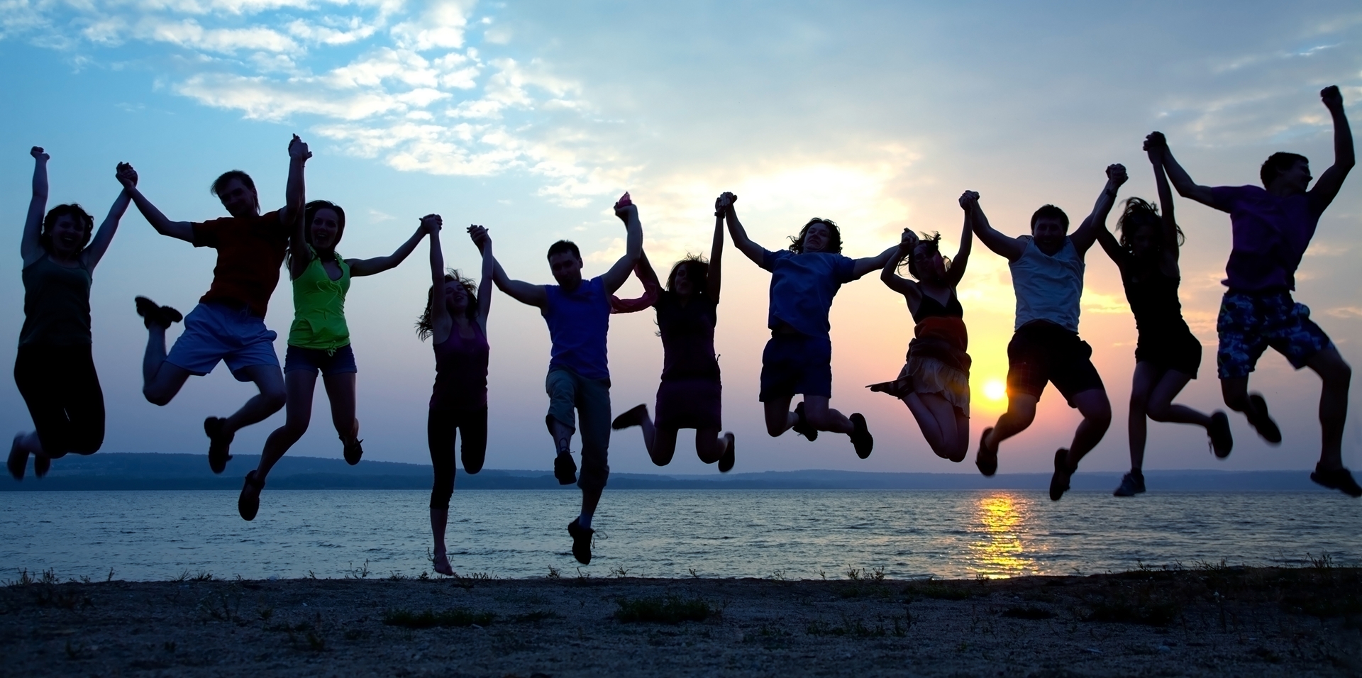 group of people holding hands and jumping