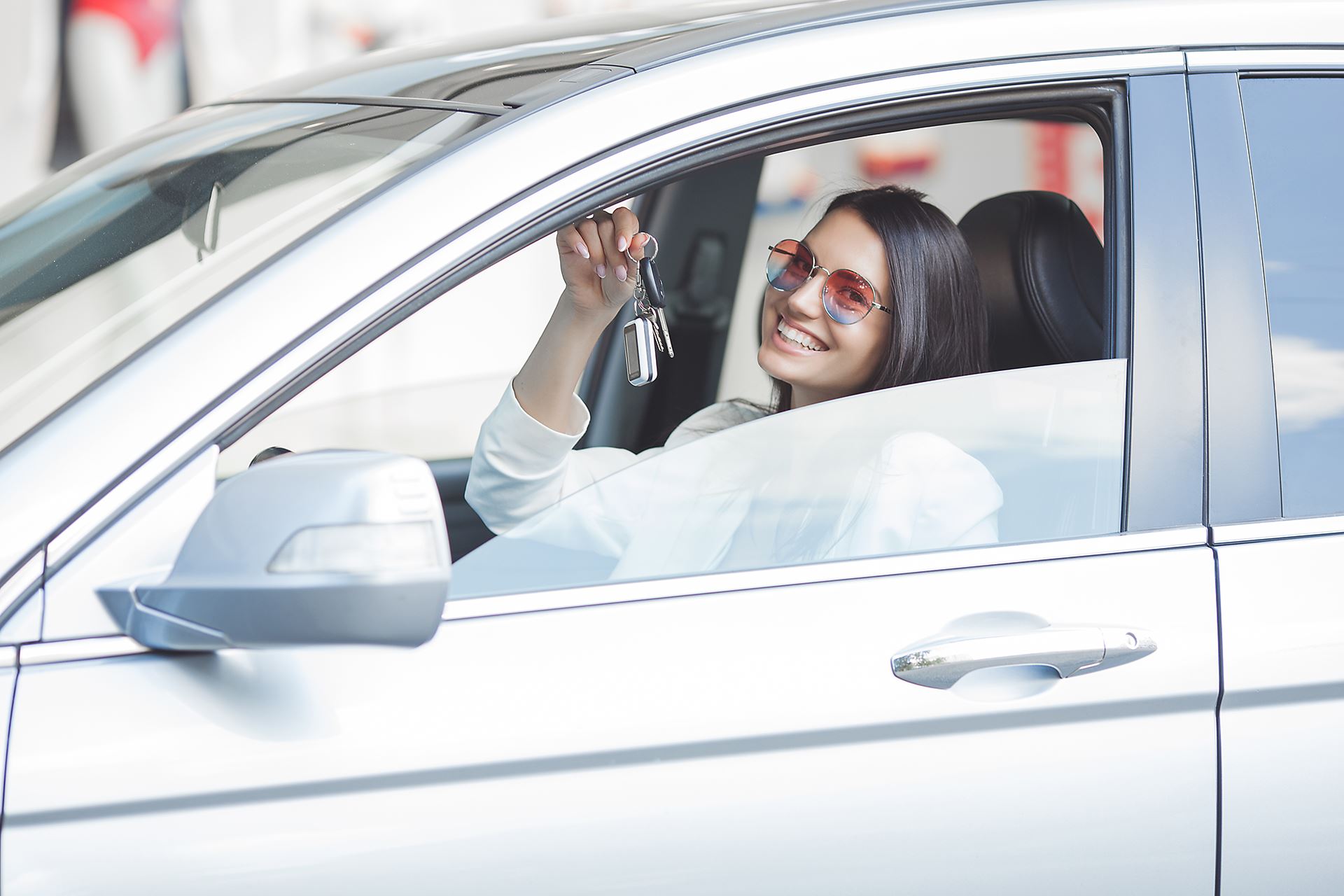 woming smiling in car holding keys
