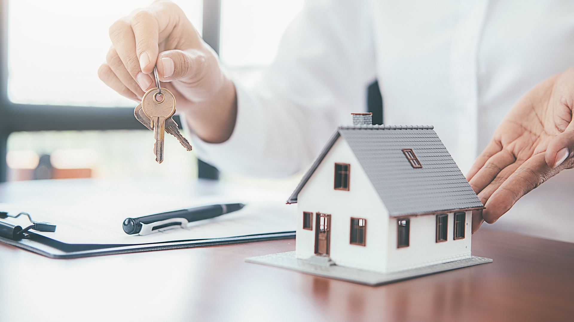 woman holding keys next to a model home