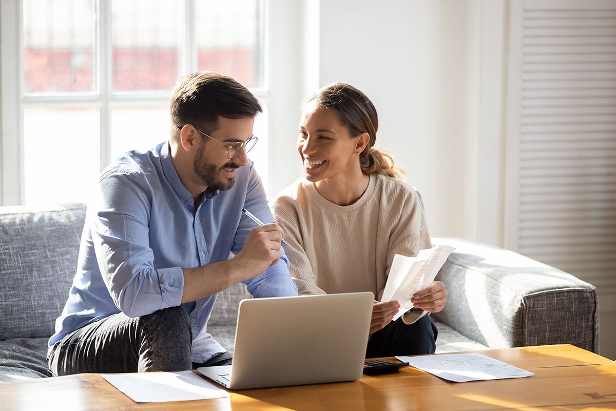 happy couple paying bills using online banking